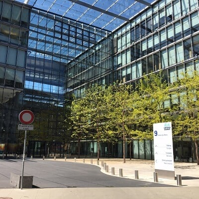 Swiss Innovation Hub - Geneva. Outside of the building on a sunny day with trees in the foreground.